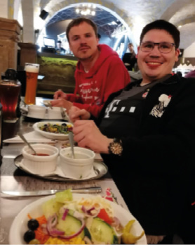 Zwei junge Männder mit Behinderung essen im Brauhaus.