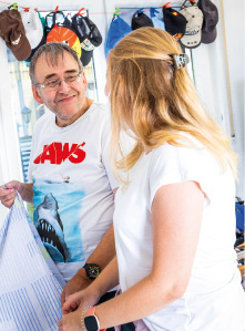 Eine Mitarbeiterin des Karrens hilft einen Mann mit Behinderung beim Betten beziehen.